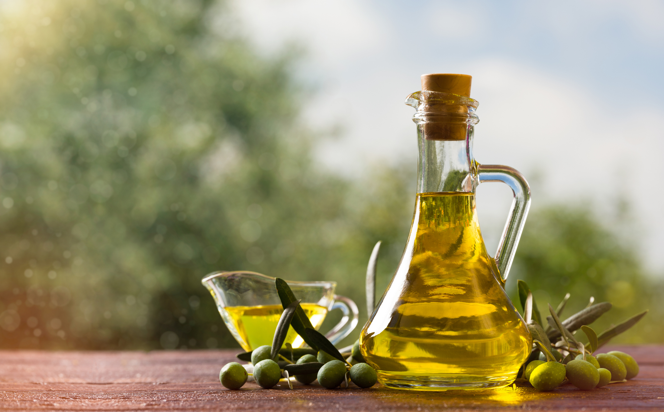 Olivenöl in Flasche mit Oliven